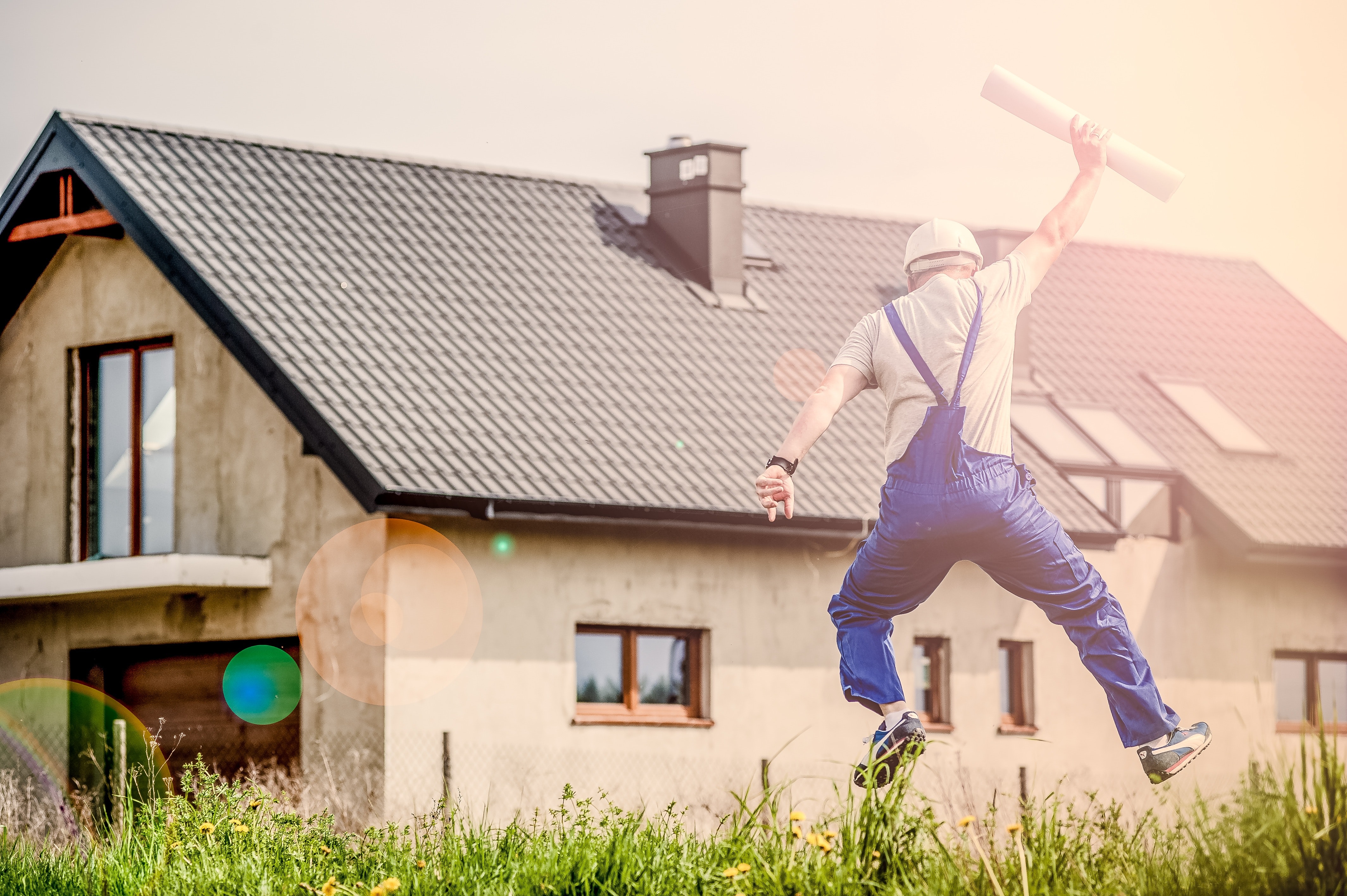Image of joyous construction worker in front of a house
